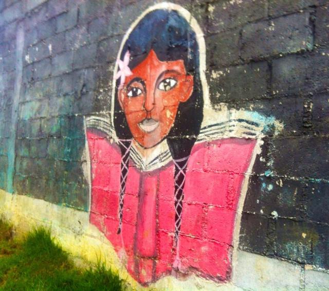 Young girl painted on the side of one of the school buildings.